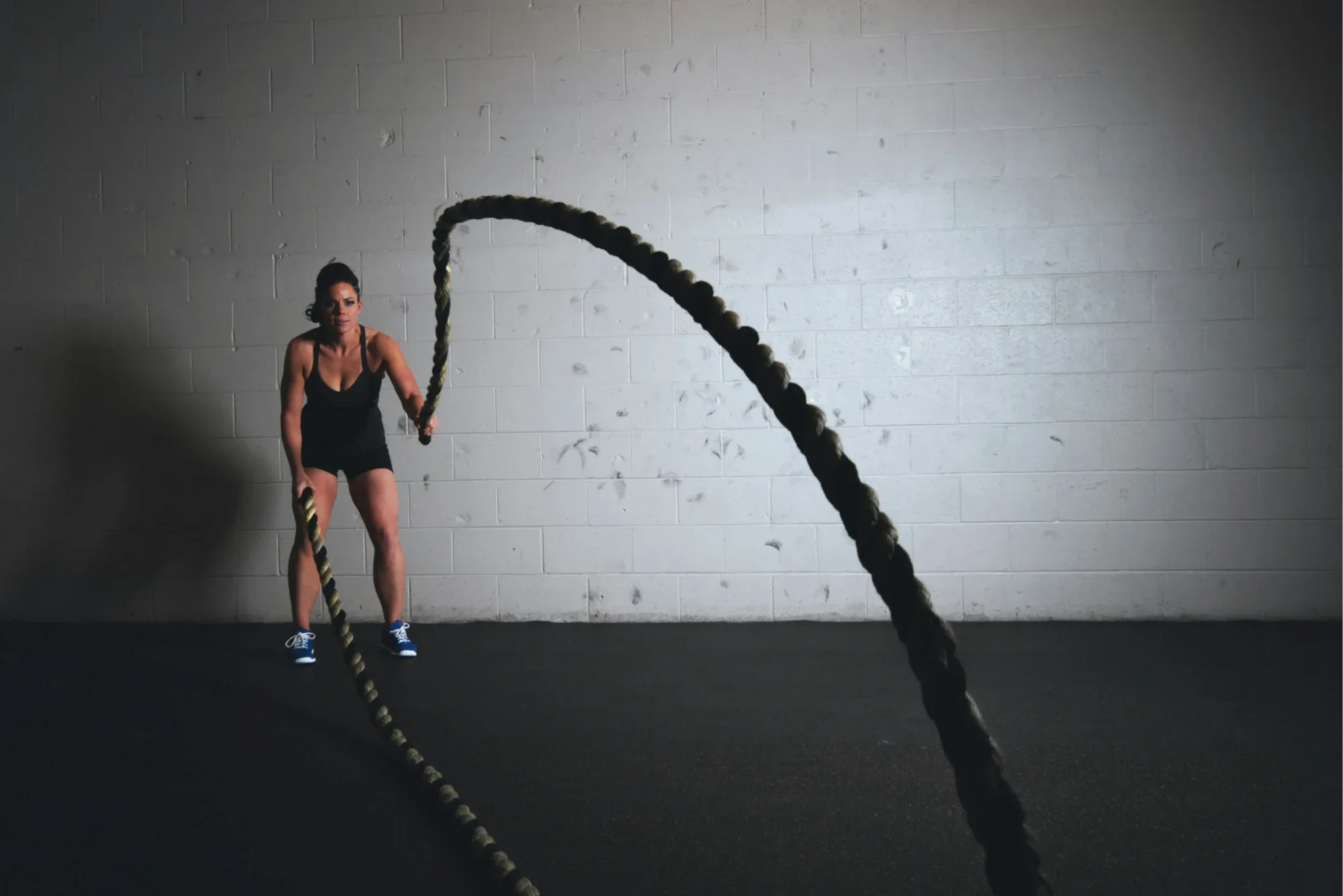 Mujer entrenando con cuerdas como símbolo del esfuerzo necesario para impulsar el cambio y el crecimiento empresarial
